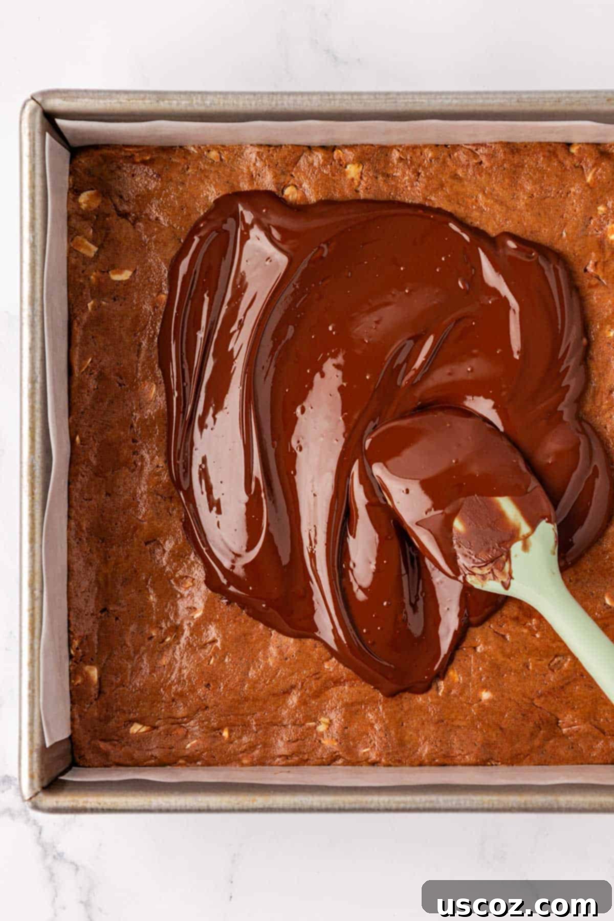 Protein-Packed Chocolate Bars 8 Spreading melted chocolate evenly over the top of the protein bars with a rubber spatula