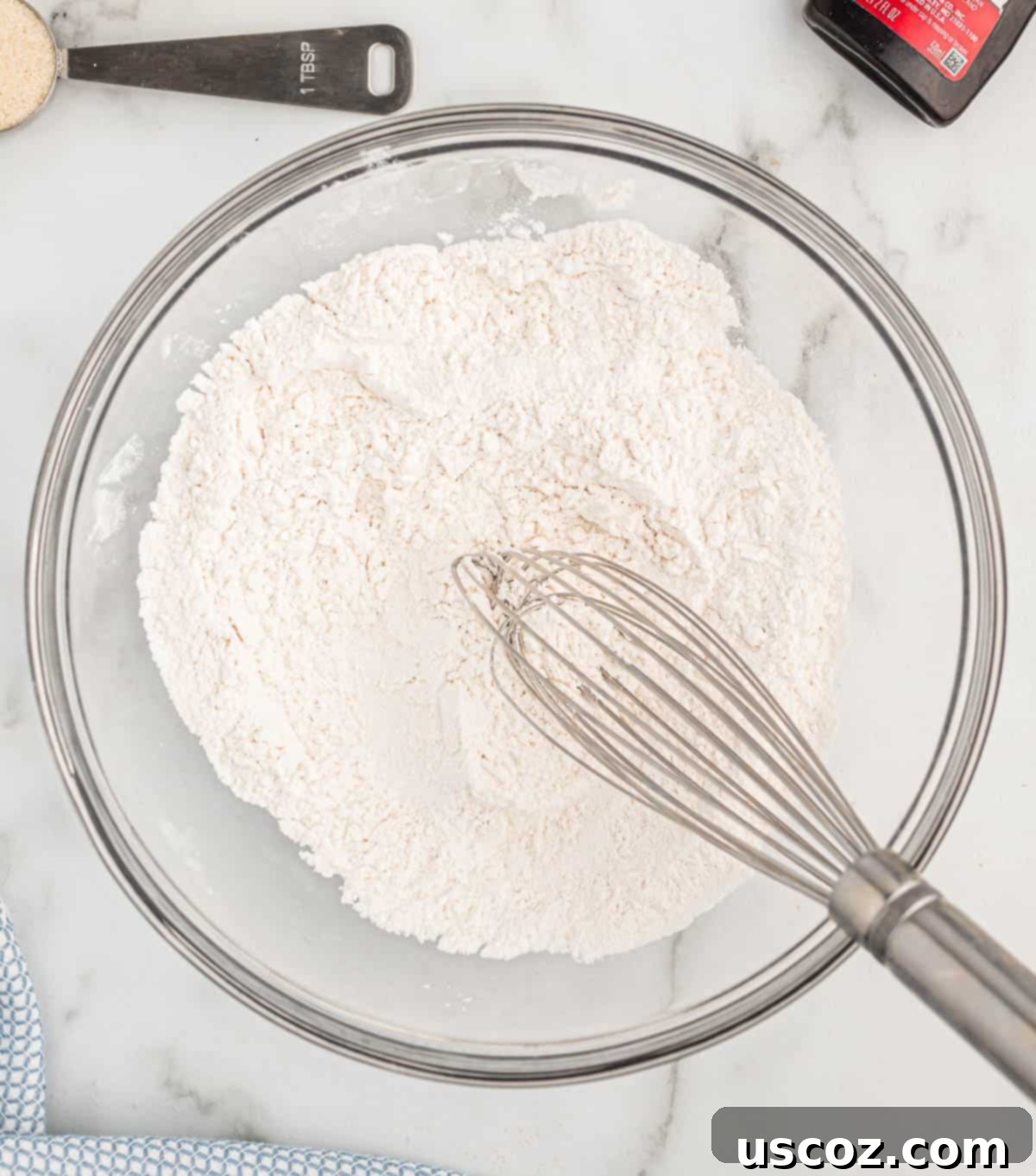 Breakfast Pancake Bites 5 Dry ingredients (flour, baking powder, salt) whisked together in a white mixing bowl.