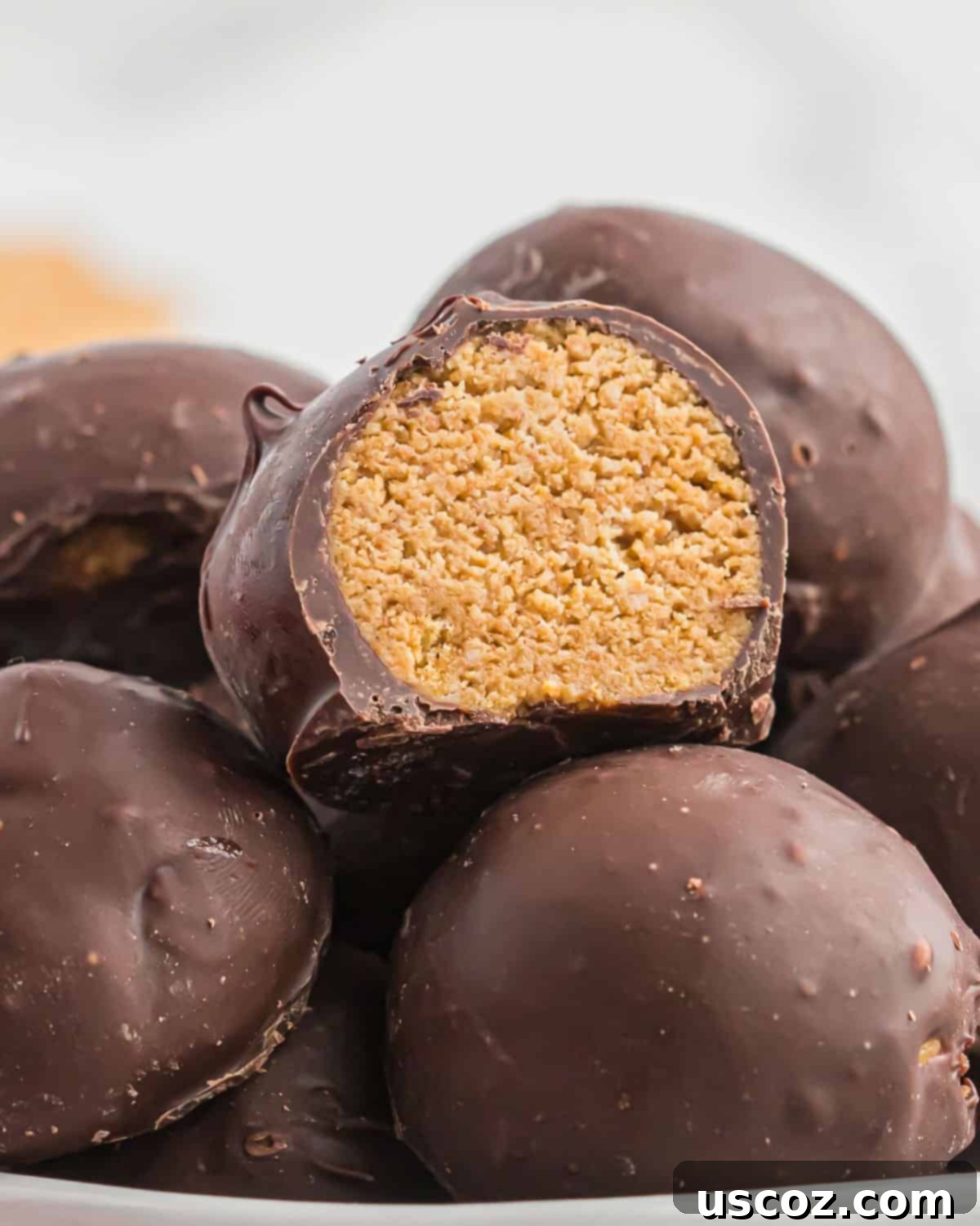No-Bake Peanut Butter Graham Bites 3 A close-up of a stack of chocolate-covered peanut butter balls with graham crackers, showing their delightful coating and tempting texture.