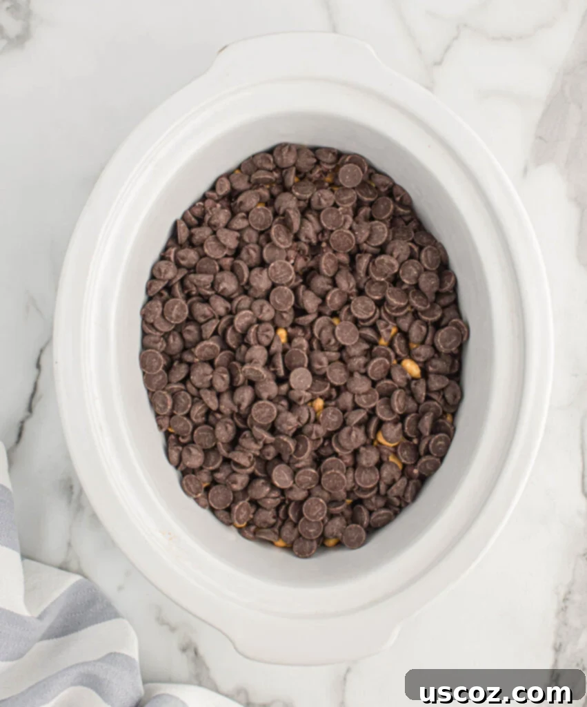 Slow Cooker Chocolate Peanut Clusters 6 chocolate chips layered over peanuts in the slow cooker
