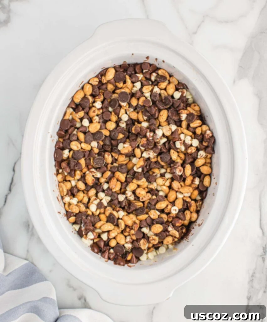Slow Cooker Chocolate Peanut Clusters 9 mixing together the peanuts with the melted chocolate chips