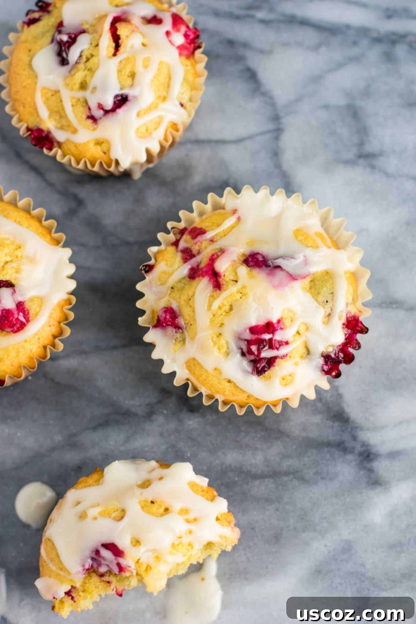 Luscious Cranberry Cream Cheese Muffins 3 Stacked cranberry cream cheese muffins with glaze on a white plate, ready to be enjoyed as a festive holiday treat.