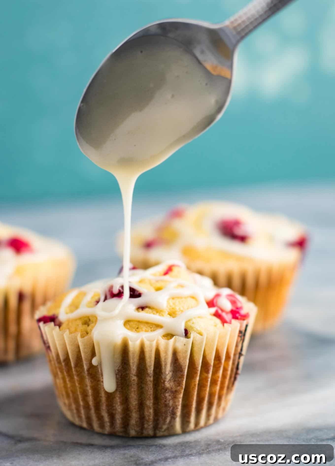 Luscious Cranberry Cream Cheese Muffins 6 Several cranberry cream cheese muffins on a white serving plate, highlighting their soft texture and the tart cranberries.