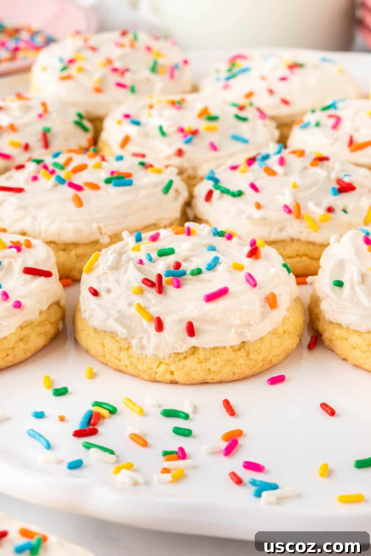 Simple Cake Mix Delights 19 Frosted cake mix sugar cookies topped with colorful sprinkles, arranged beautifully on a serving plate.