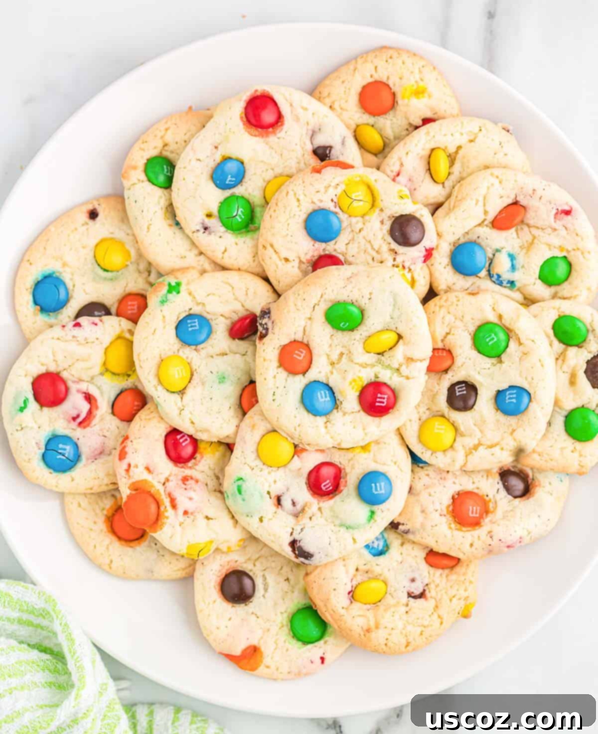 Fluffy White Cake Mix Cookies 2 Delicious M&M cookies on a white plate, showcasing their vibrant colors and perfect texture.