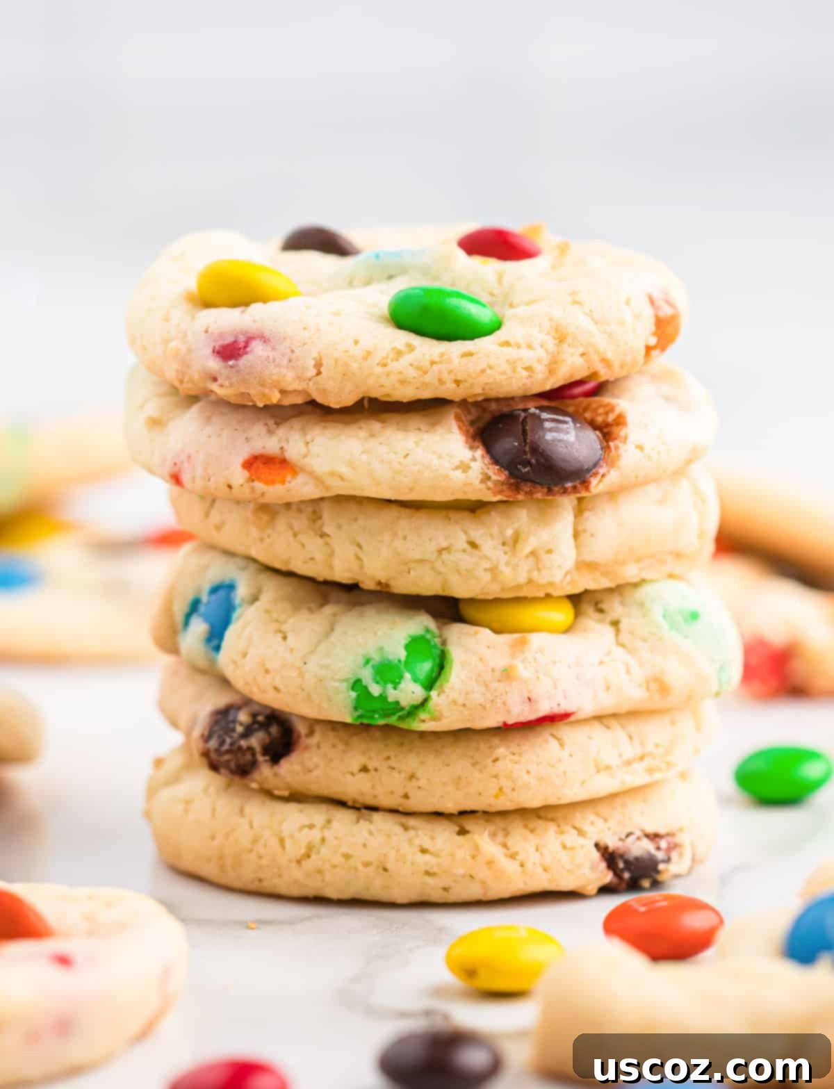 Fluffy White Cake Mix Cookies 11 A stack of perfectly baked white cake mix cookies, showing off their soft centers and colorful M&M's.