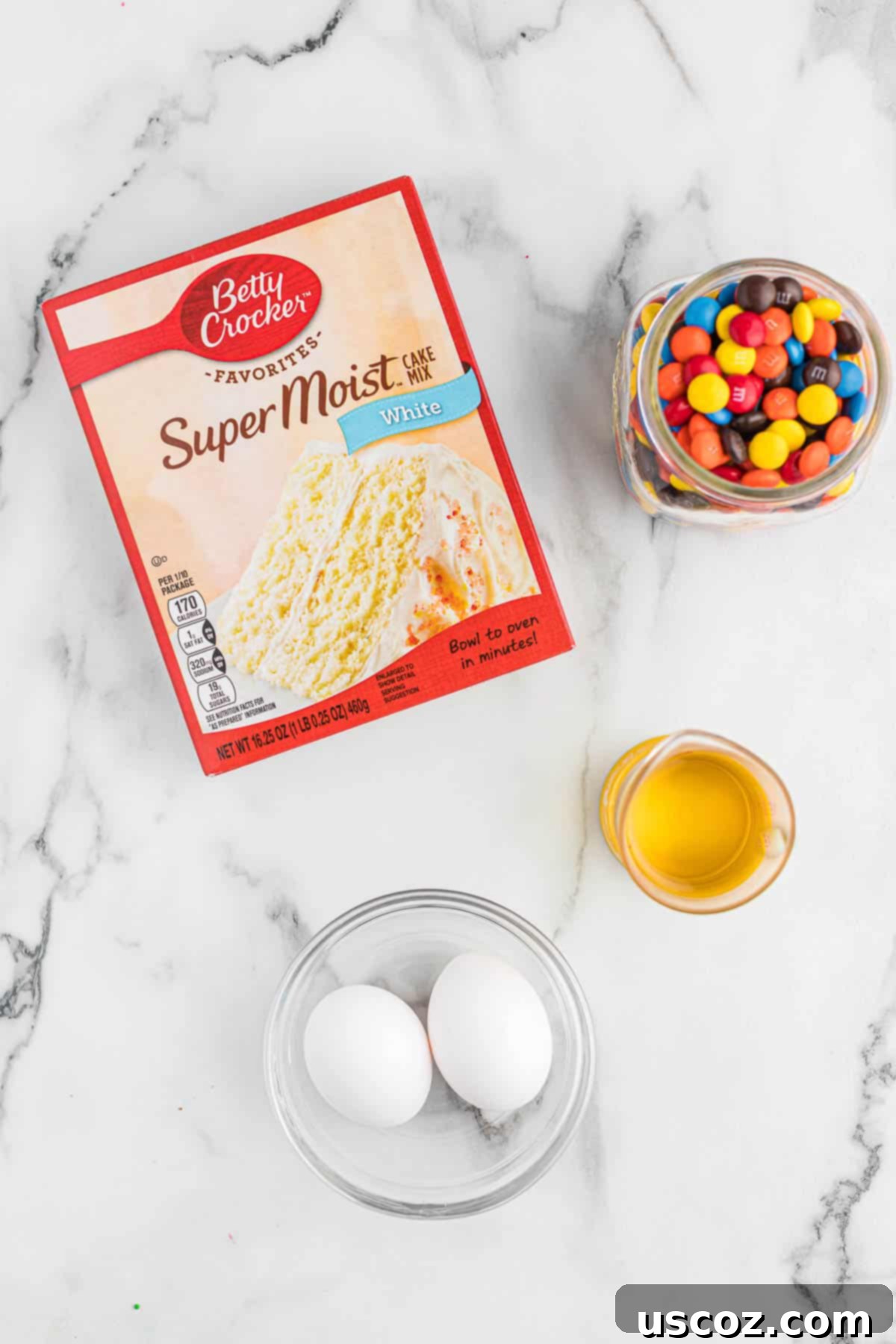 Fluffy White Cake Mix Cookies 4 The four simple ingredients: white cake mix, olive oil, eggs, and M&M's, laid out for baking.