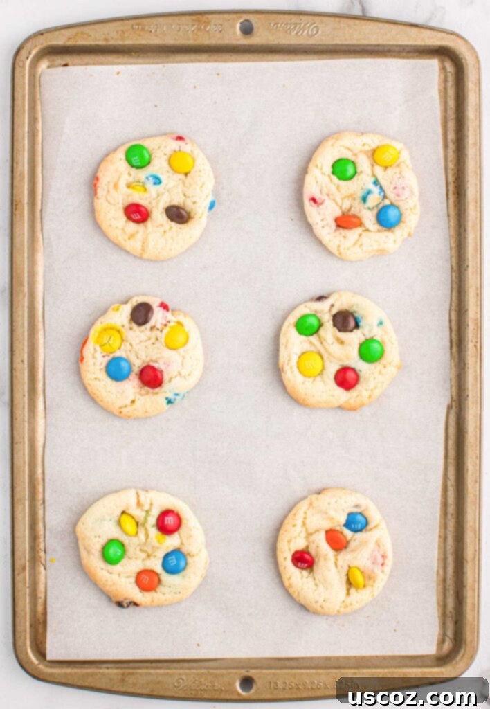 Fluffy White Cake Mix Cookies 9 A baking sheet filled with white cake mix cookies, some topped with extra M&M's.