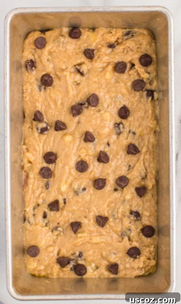 The Ultimate Chocolate Chip Banana Bread 8 Loaf pan filled with chocolate chip banana bread batter