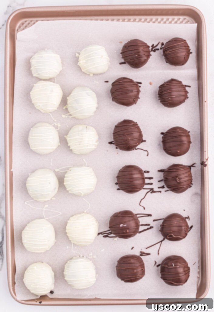 Minty Oreo Truffle Bites 11 white and dark chocolate oreo truffles on a lined baking sheet