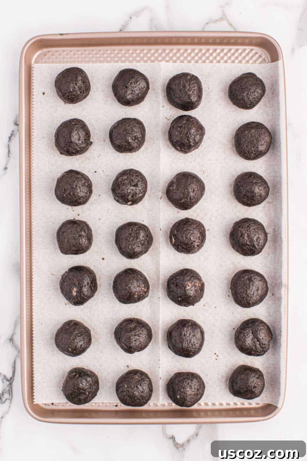 Minty Oreo Truffle Bites 7 oreo balls arranged neatly on a parchment-lined baking sheet