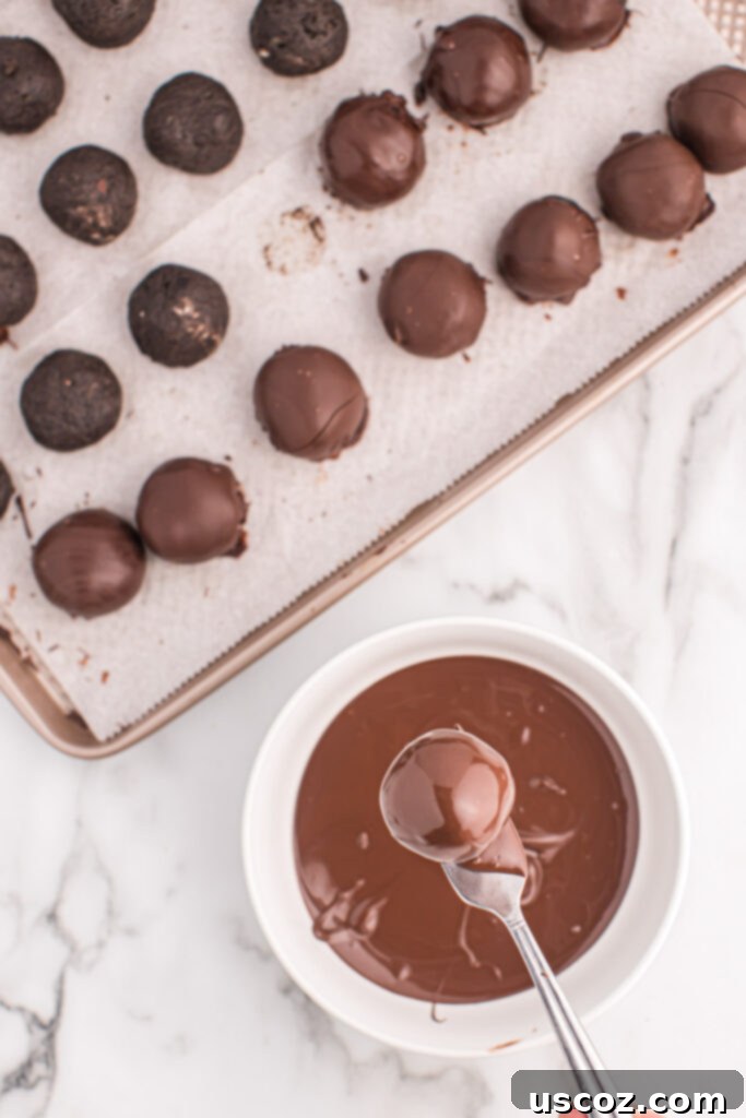 Minty Oreo Truffle Bites 8 dipping an oreo ball into melted dark chocolate