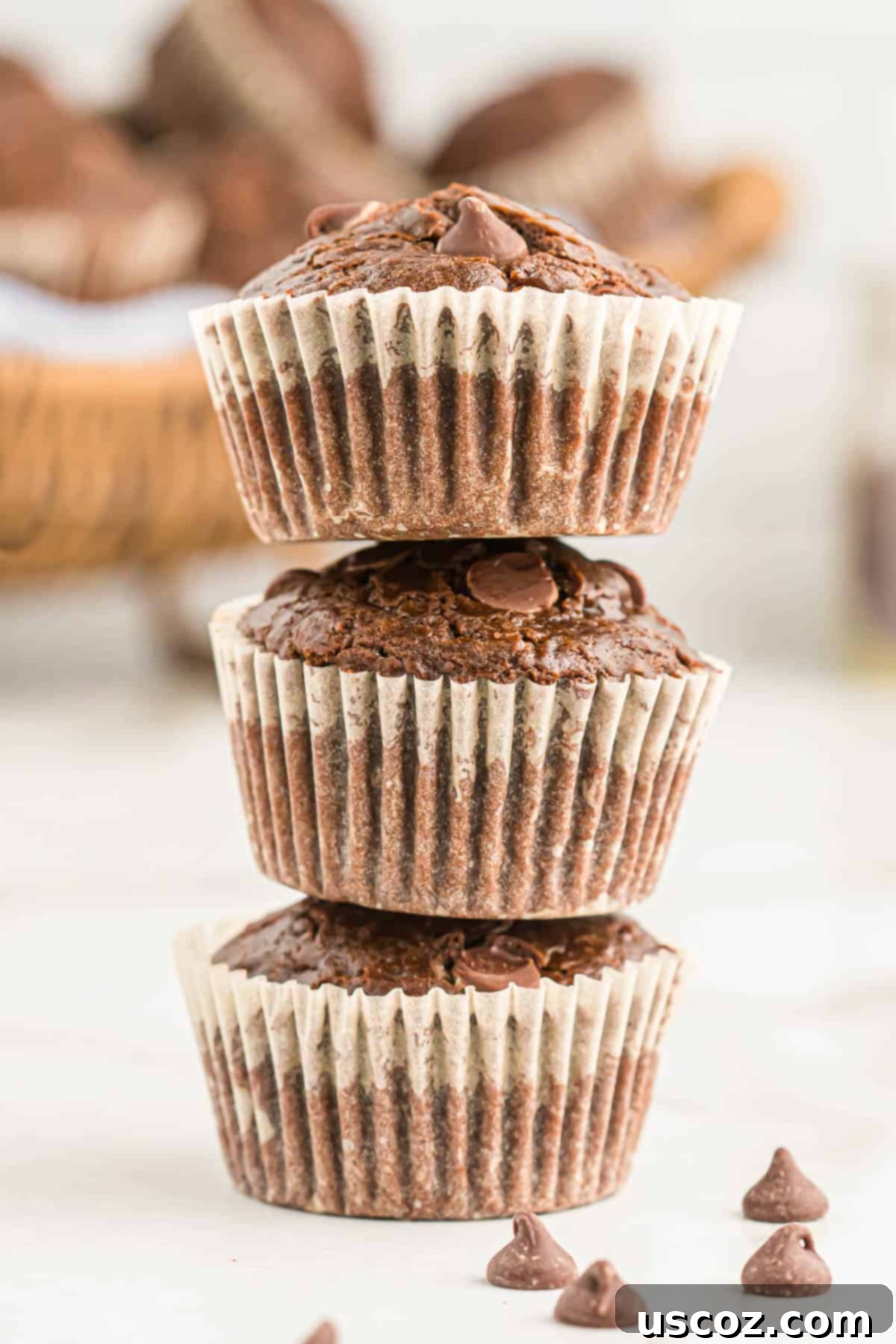 Ultimate Double Chocolate Muffins 12 double chocolate muffins stacked artfully on a cooling rack