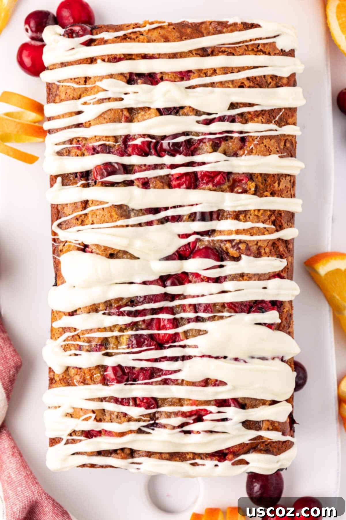Festive Cranberry Eggnog Bread 3 slice of cranberry eggnog bread with white chocolate glaze on a plate
