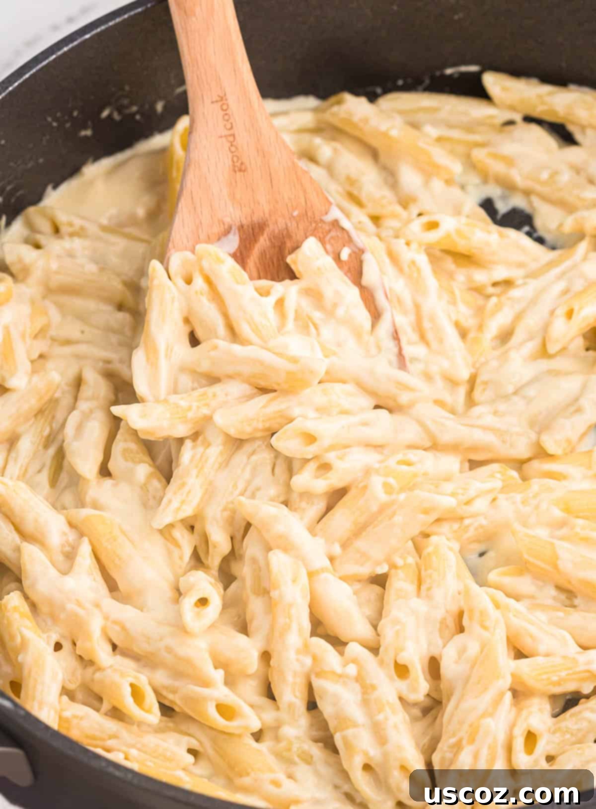 Decadent Creamy Penne 14 Another perspective of creamy penne pasta on a wooden spoon, ready to be eaten