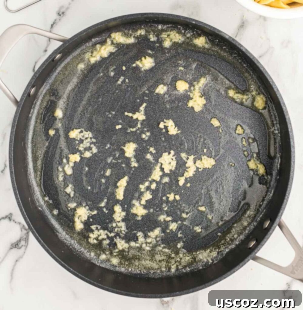 Decadent Creamy Penne 5 Minced garlic sizzling gently in melted butter in a skillet