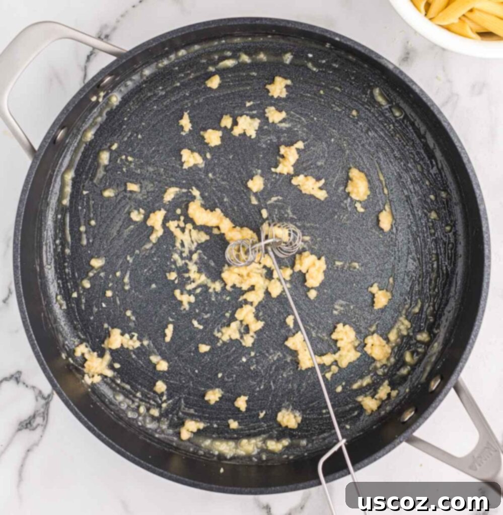 Decadent Creamy Penne 6 Whisking all-purpose flour into the butter and garlic mixture to form a roux
