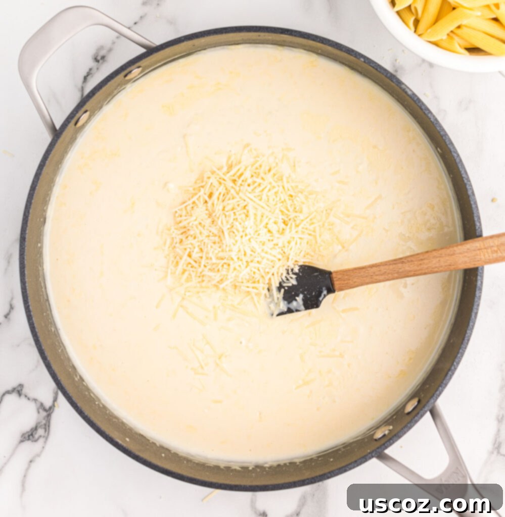 Decadent Creamy Penne 8 Freshly grated parmesan cheese being stirred into the simmering cream sauce