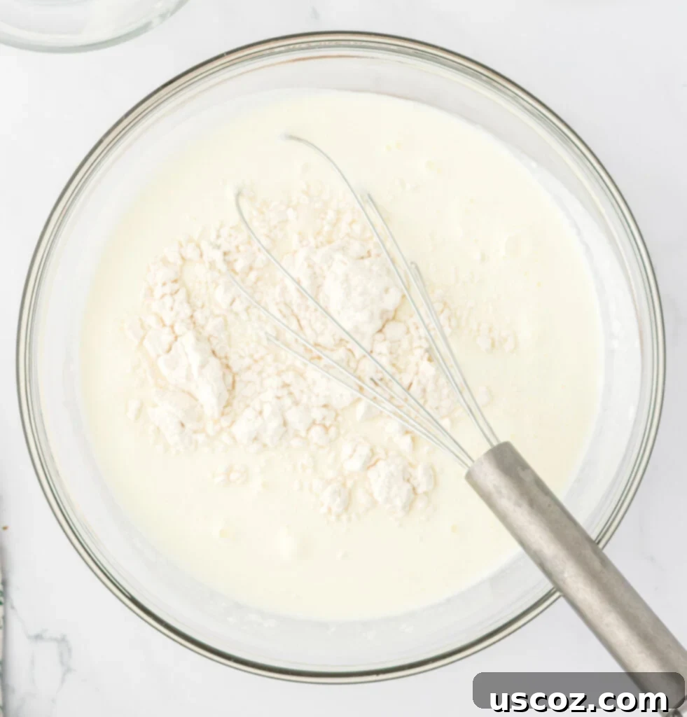Hearty Potato Comfort 12 Whole milk, heavy cream, and all-purpose flour measured out in a bowl, ready to be whisked into a smooth slurry.