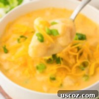 Hearty Potato Comfort 22 A warm, inviting bowl of creamy potato soup, garnished with vibrant green onions and shredded cheddar cheese.