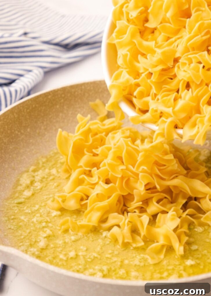 Delicious Garlic Butter Noodles 7 pouring egg noodles into garlic butter