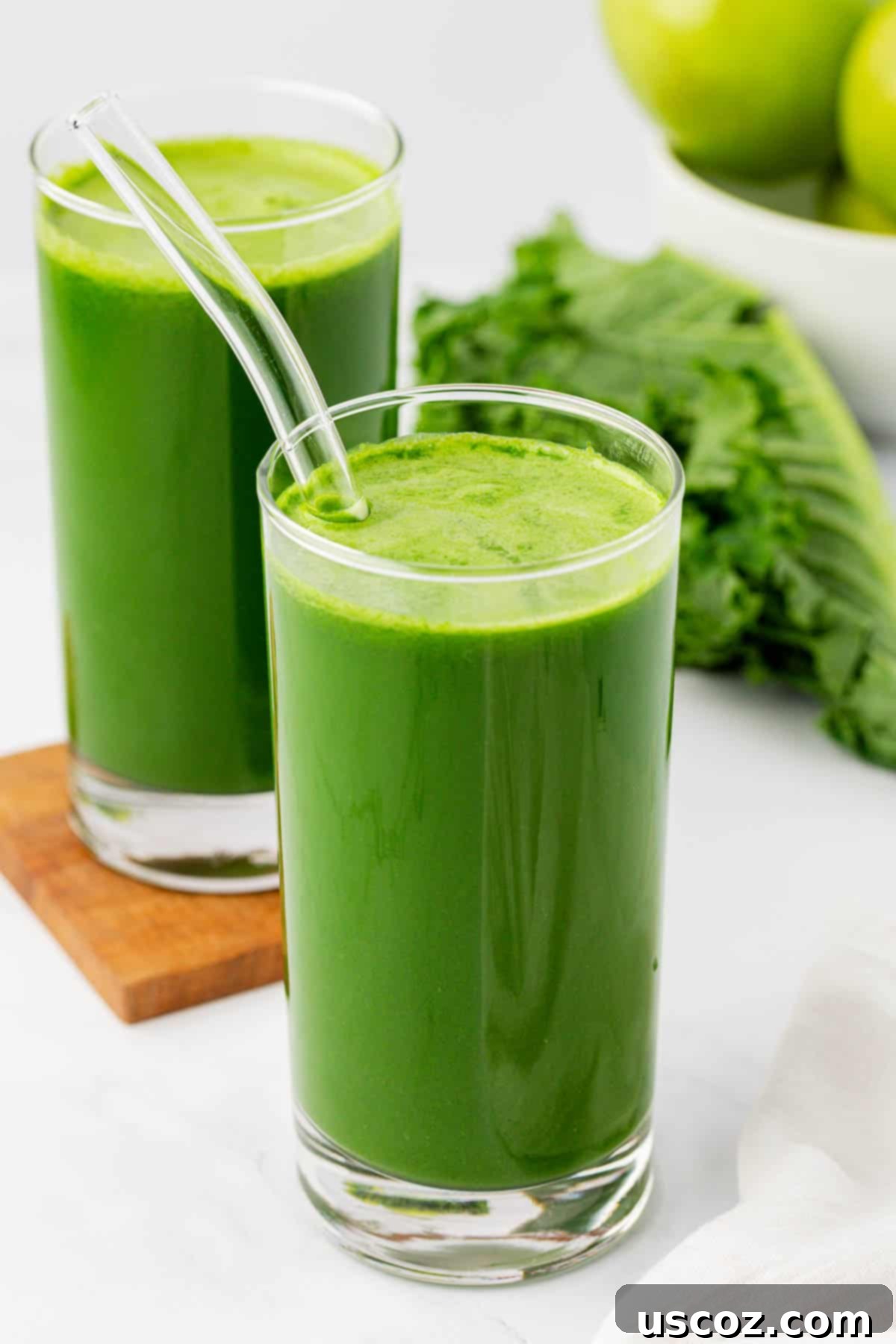 Emerald Elixir 12 A tall glass of vibrant kale juice with a straw, reflecting the light and freshness.