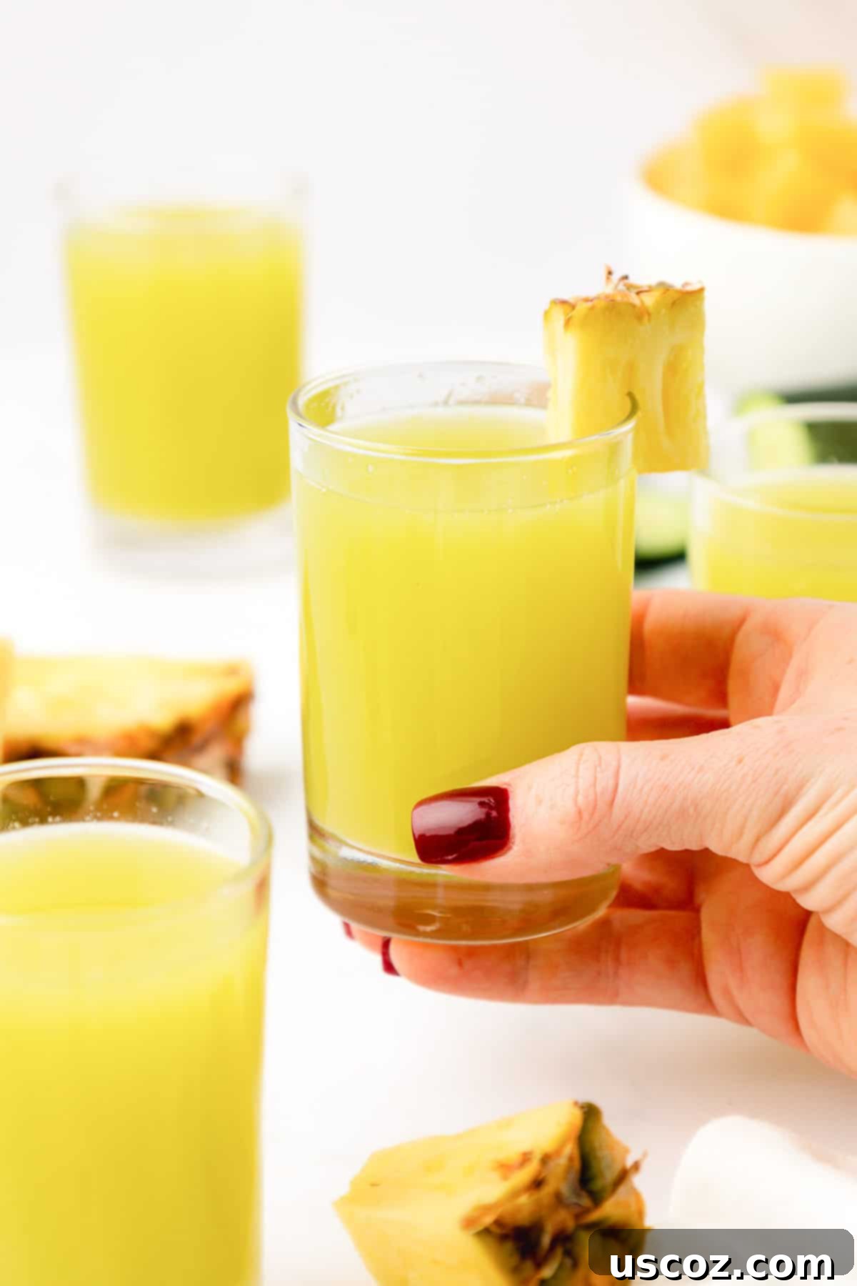 Hydrating Pineapple Cucumber Quencher 12 hand holding a glass of pineapple cucumber juice