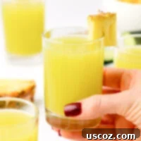Hydrating Pineapple Cucumber Quencher 13 hand holding a glass of pineapple cucumber juice