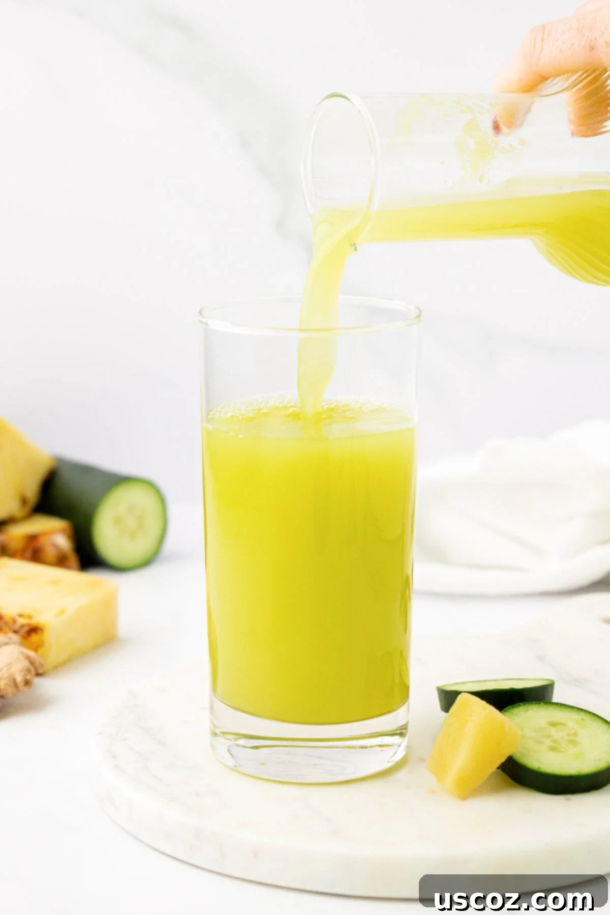 Hydrating Pineapple Cucumber Quencher 7 pouring pineapple cucumber juice into a glass