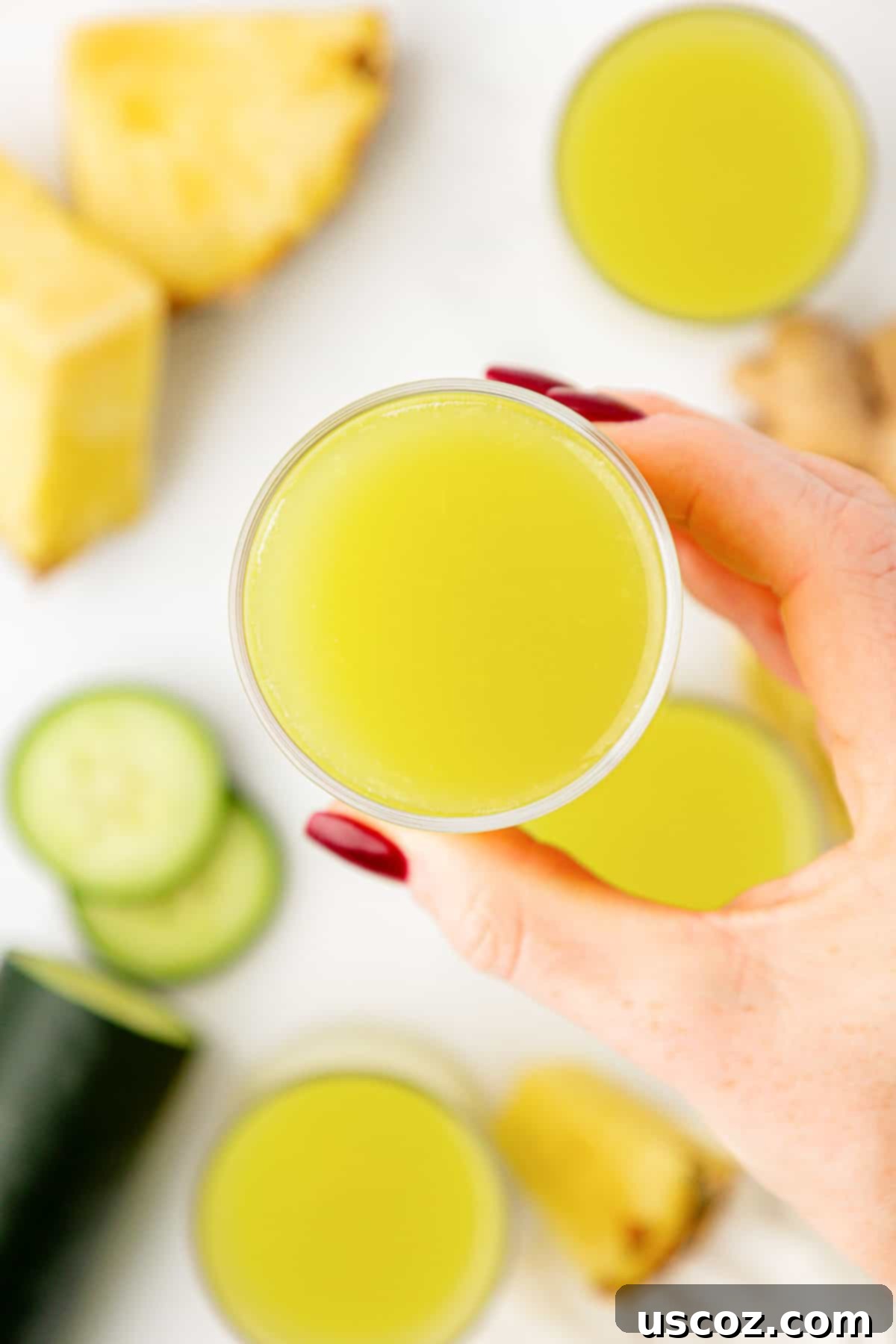 Hydrating Pineapple Cucumber Quencher 9 hand holding a glass of pineapple cucumber juice
