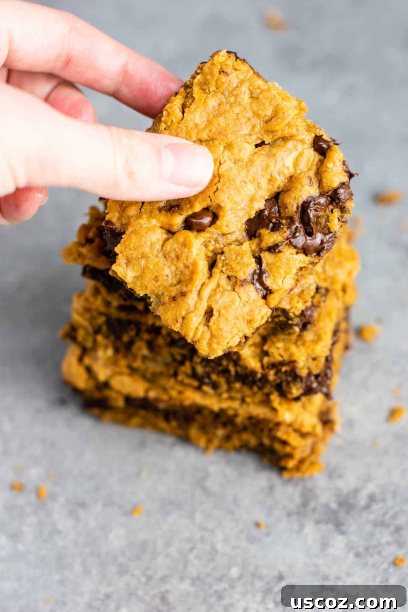 The Best Gluten-Free Cookie Bars 3 A close-up of a stack of healthy gluten-free cookie bars, revealing their soft texture and abundant chocolate chips. These decadent yet wholesome bars are dairy-free and perfect for any dessert lover. #glutenfree #cookiebars #dessert #dairyfree #healthydessert #glutenfreedessert #glutenfreerecipe #glutenfreecookiebars