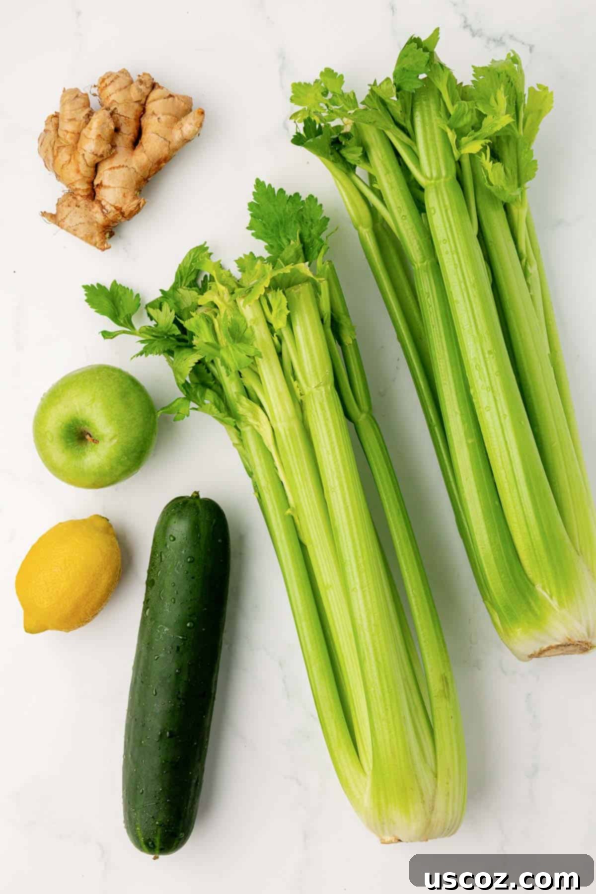 Celery Juice 4 Fresh celery, cucumber, lemon, green apple, and ginger laid out on a table