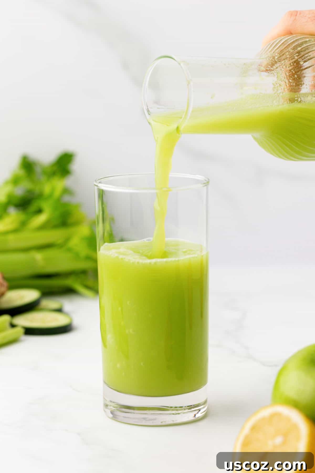 Celery Juice 7 Pouring celery juice into a glass from a pitcher
