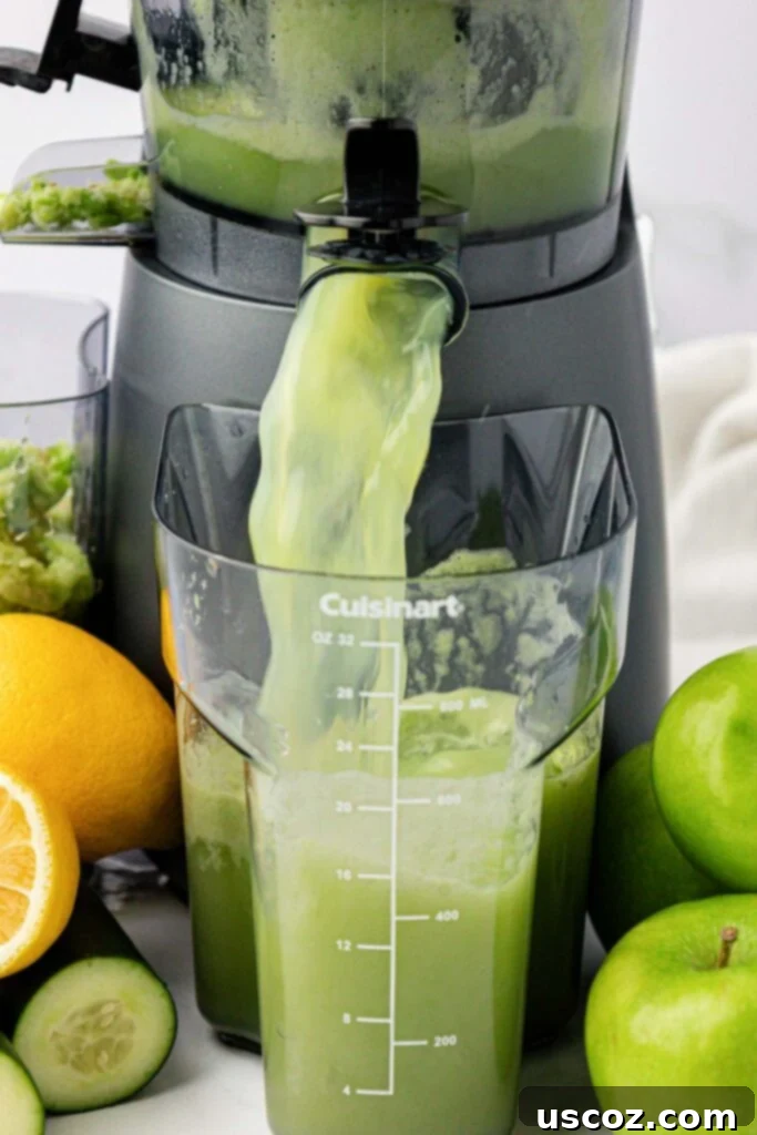 Emerald Zest Drink 5 Juicer extracting fresh green apple juice into a collection canister.