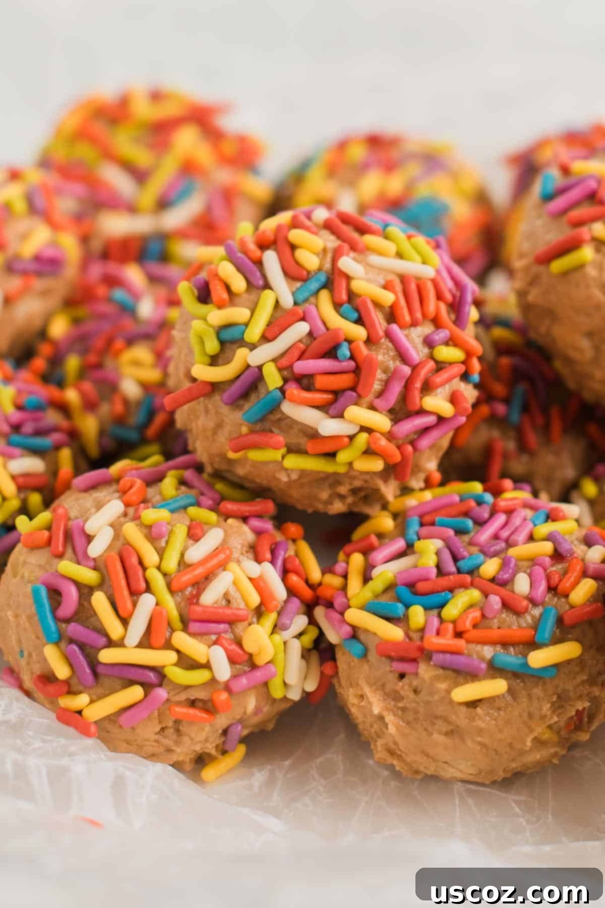 Funfetti Protein Bites 14 Various birthday cake protein balls with colorful sprinkles on a white textured surface.