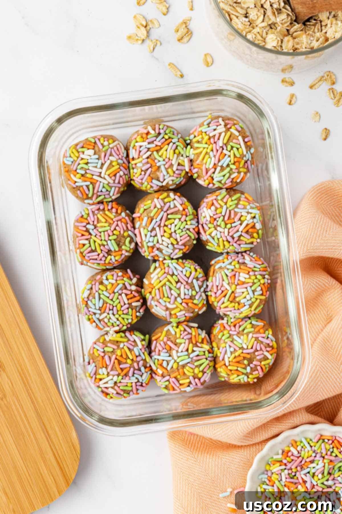 Funfetti Protein Bites 3 Close-up of three Birthday Cake Protein Balls on a white surface, showcasing the sprinkles.