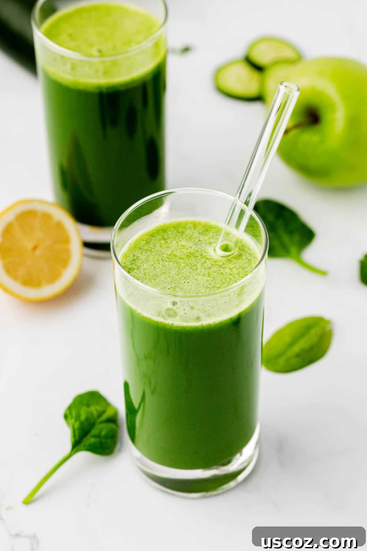 Vibrant Green Elixir 2 Spinach juice in a clear glass with a straw, garnished with a spinach leaf