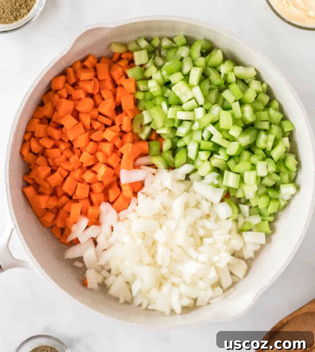 Diced carrots, celery, and onion in a skillet ready for sautéing for vegan stuffing