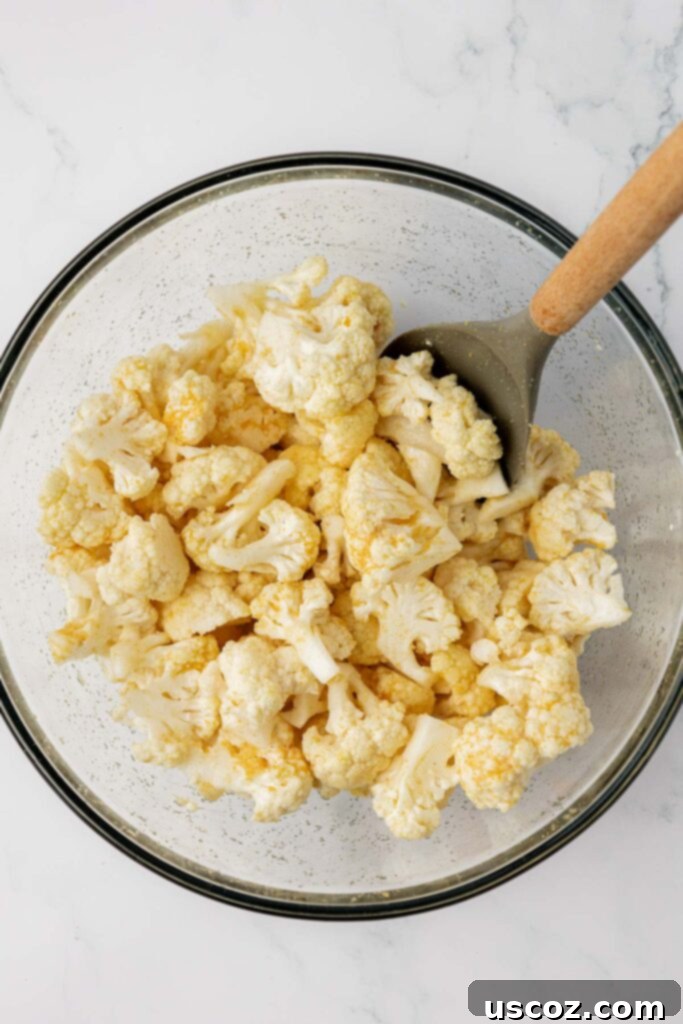 Golden Cheesy Roasted Cauliflower 11 stirring the spices and oil into the cauliflower florets