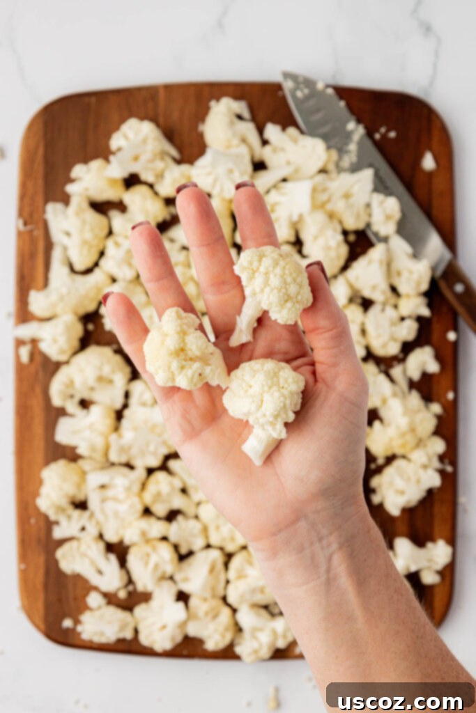 Golden Cheesy Roasted Cauliflower 8 hand holding cauliflower florets to show the size