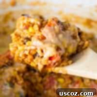 Hearty Vegetarian Mexican Bake 16 Taking a scoop of vegetarian Mexican rice casserole from the dish