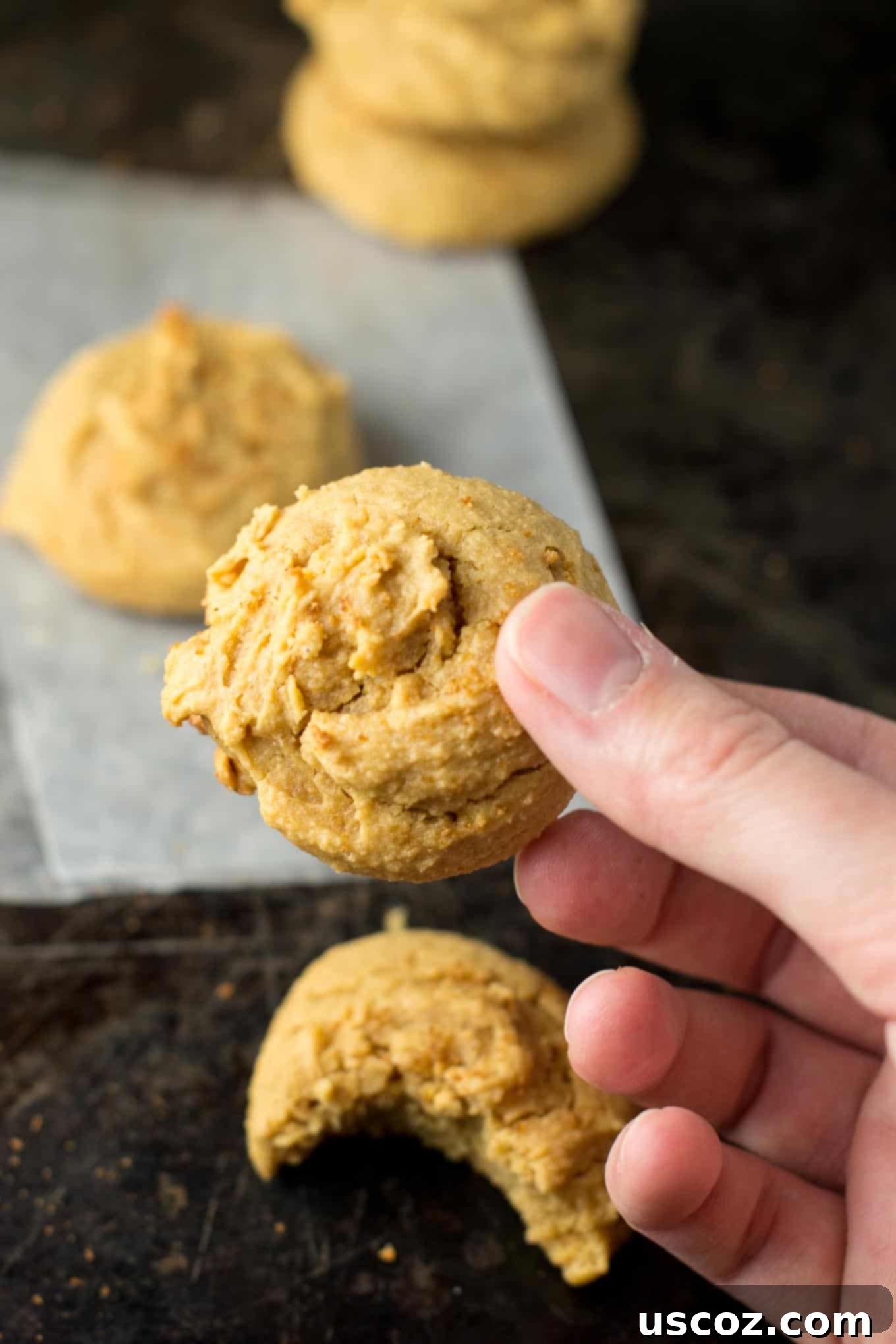 A batch of freshly baked gluten-free peanut butter cookies cooling on a wire rack.