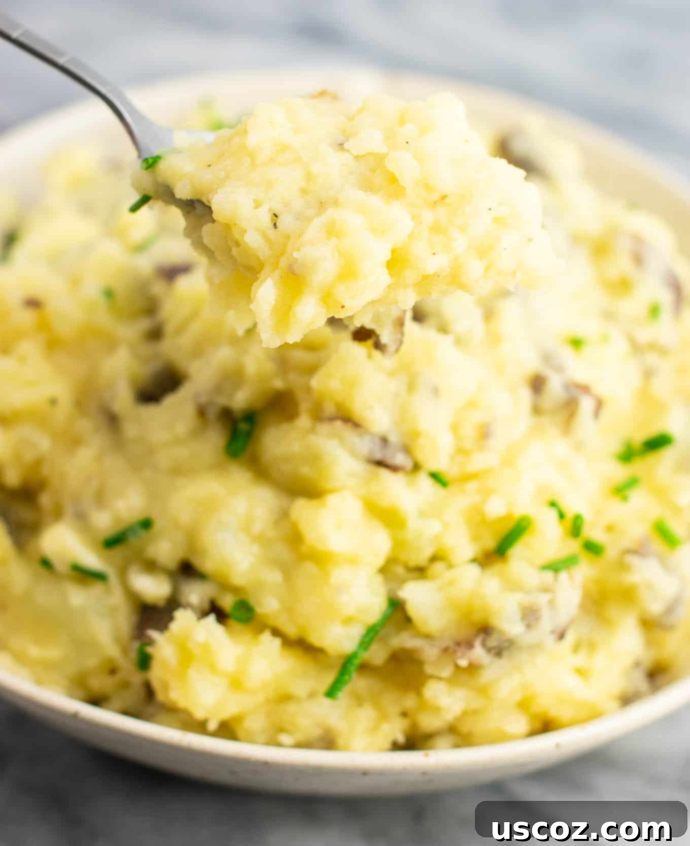 Creamy Vegan Mashed Potatoes 6 A serving spoon lifting a generous scoop of vegan mashed potatoes, highlighting their fluffy and creamy texture.