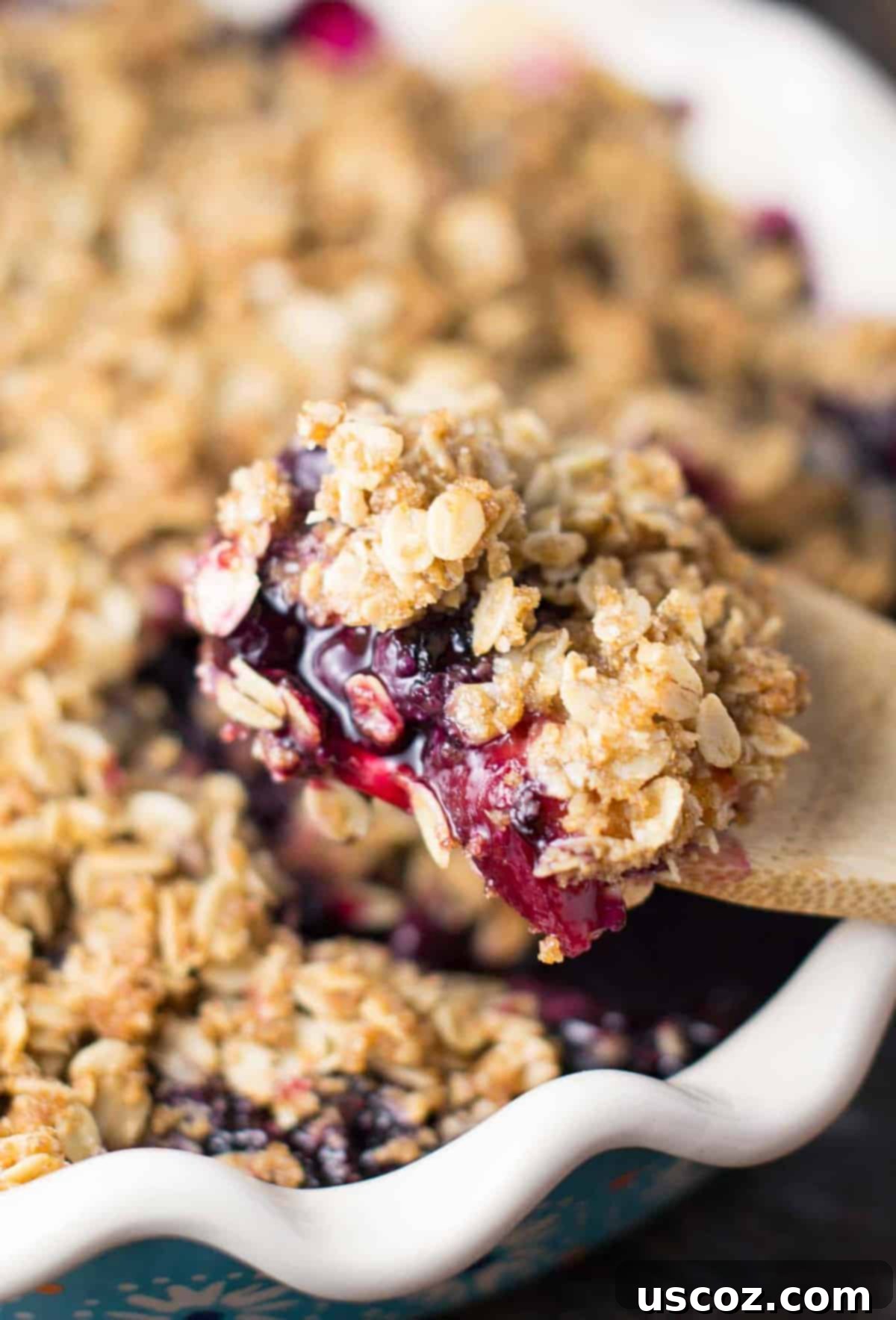 Close-up of baked gluten-free vegan blueberry peach crisp showing the golden topping