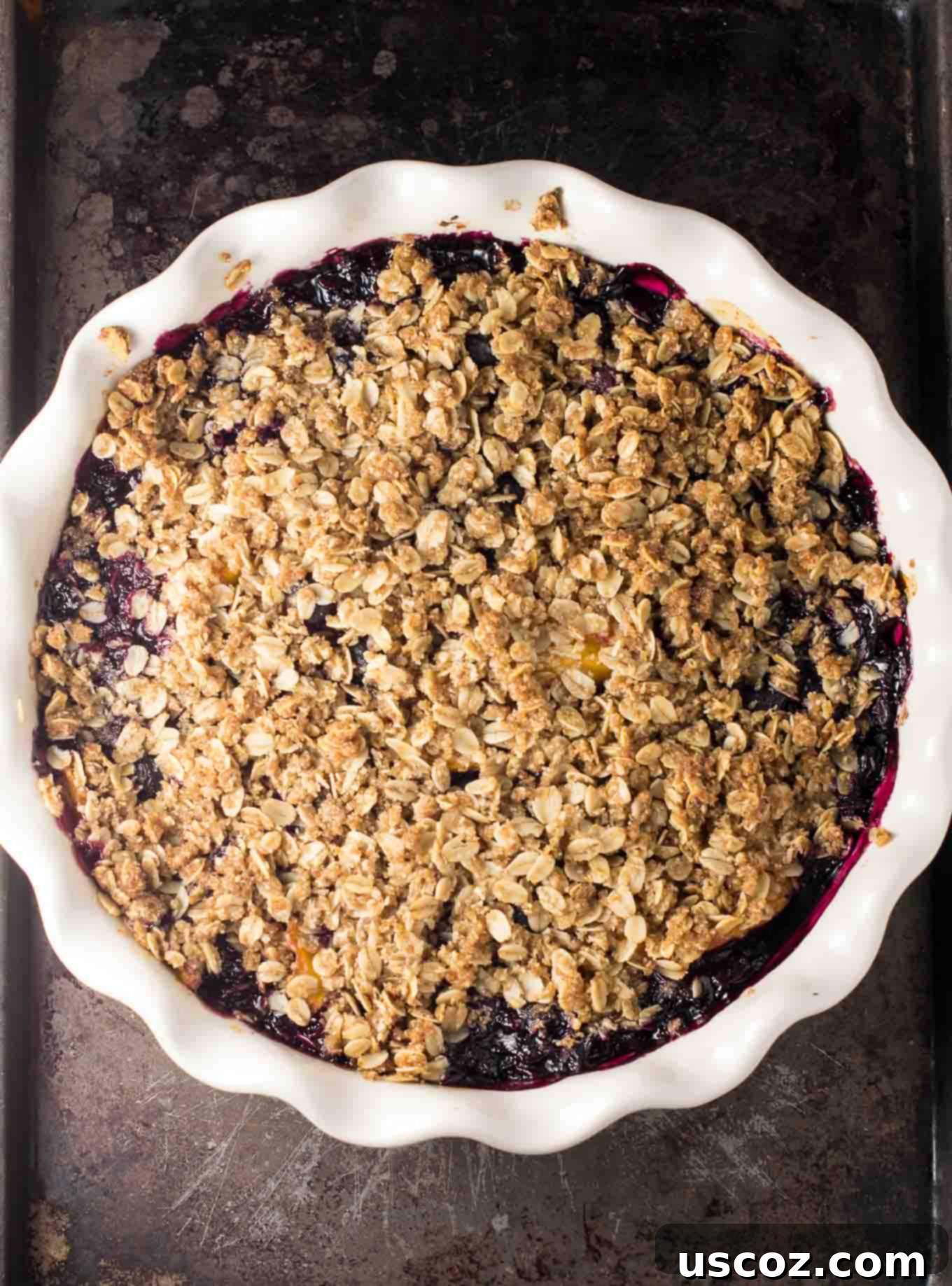 Gluten-free vegan blueberry peach dessert with a scoop missing