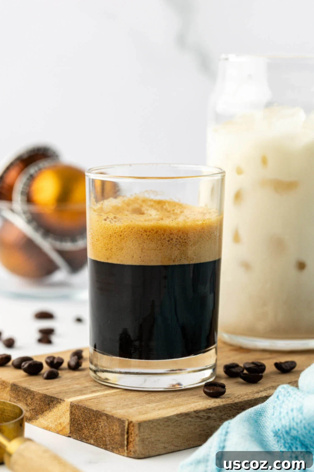 Silky Cold Espresso 6 A close-up shot of two freshly brewed espresso shots in a small glass, with rich crema on top, ready to be added to an iced latte.