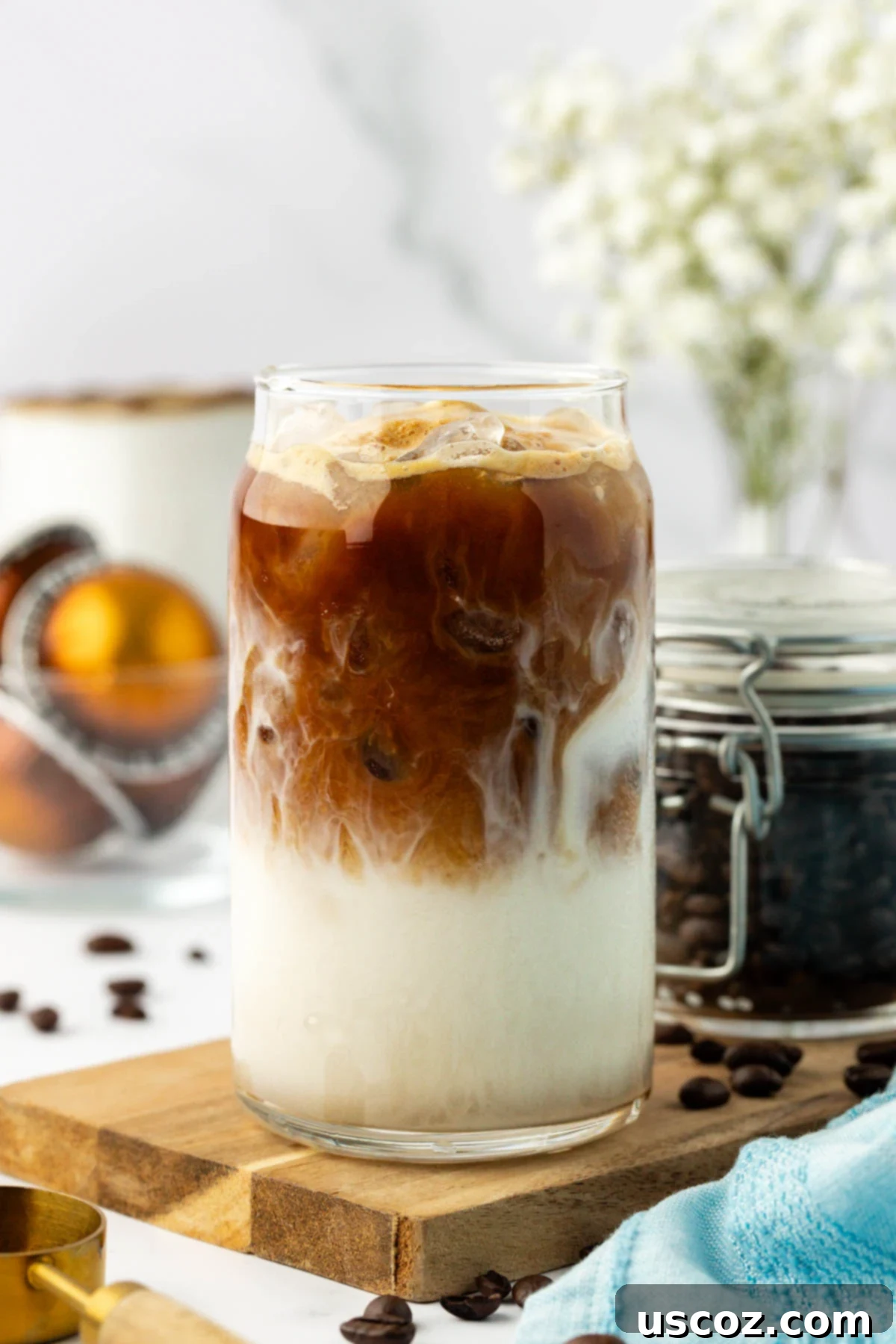 Silky Cold Espresso 10 A vibrant iced latte in a clear glass, with the dark espresso and light milk artfully swirled, resting on a textured surface, ready to be enjoyed.