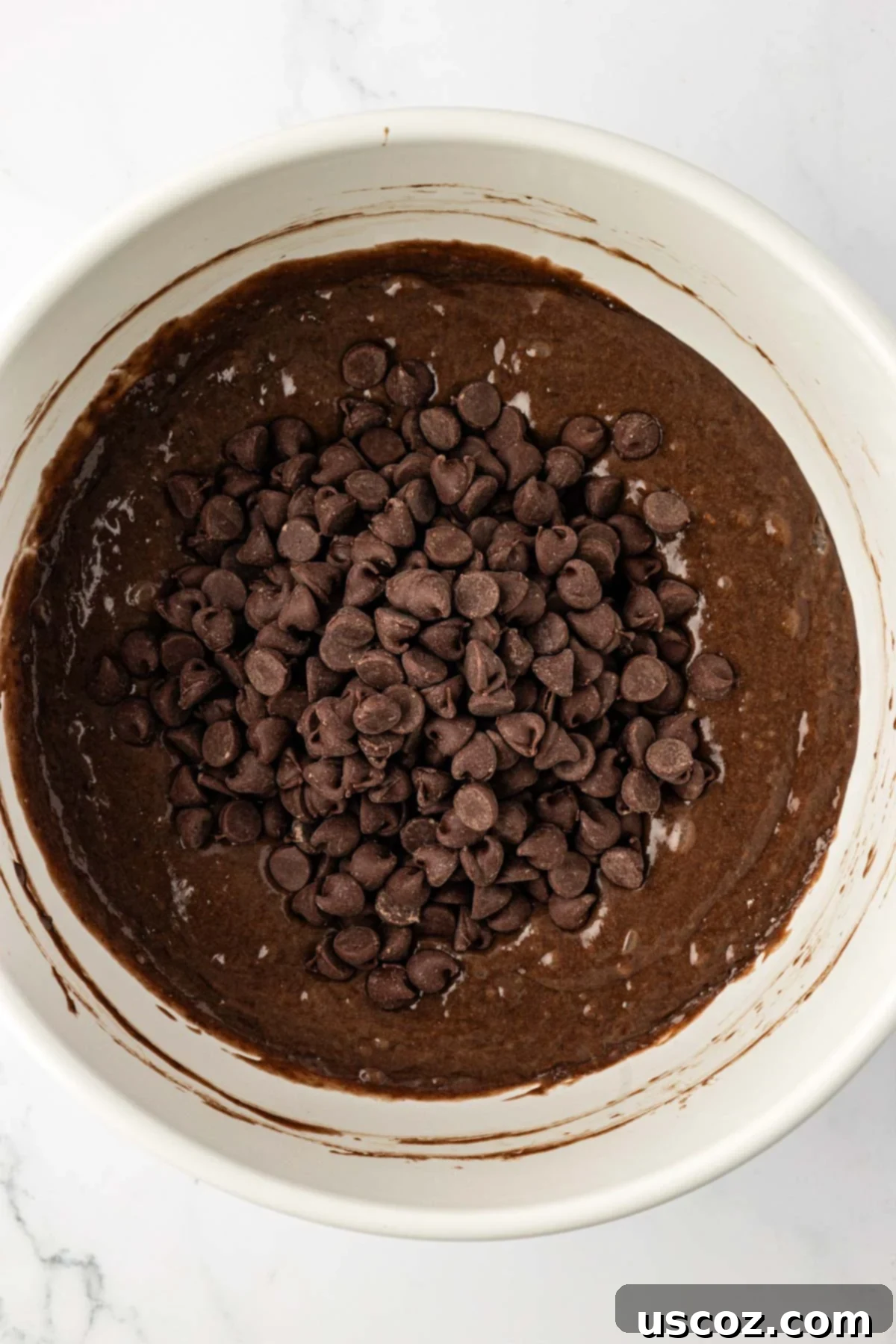 Irresistible Double Chocolate Cake Mix Muffins 9 adding chocolate chips to the batter