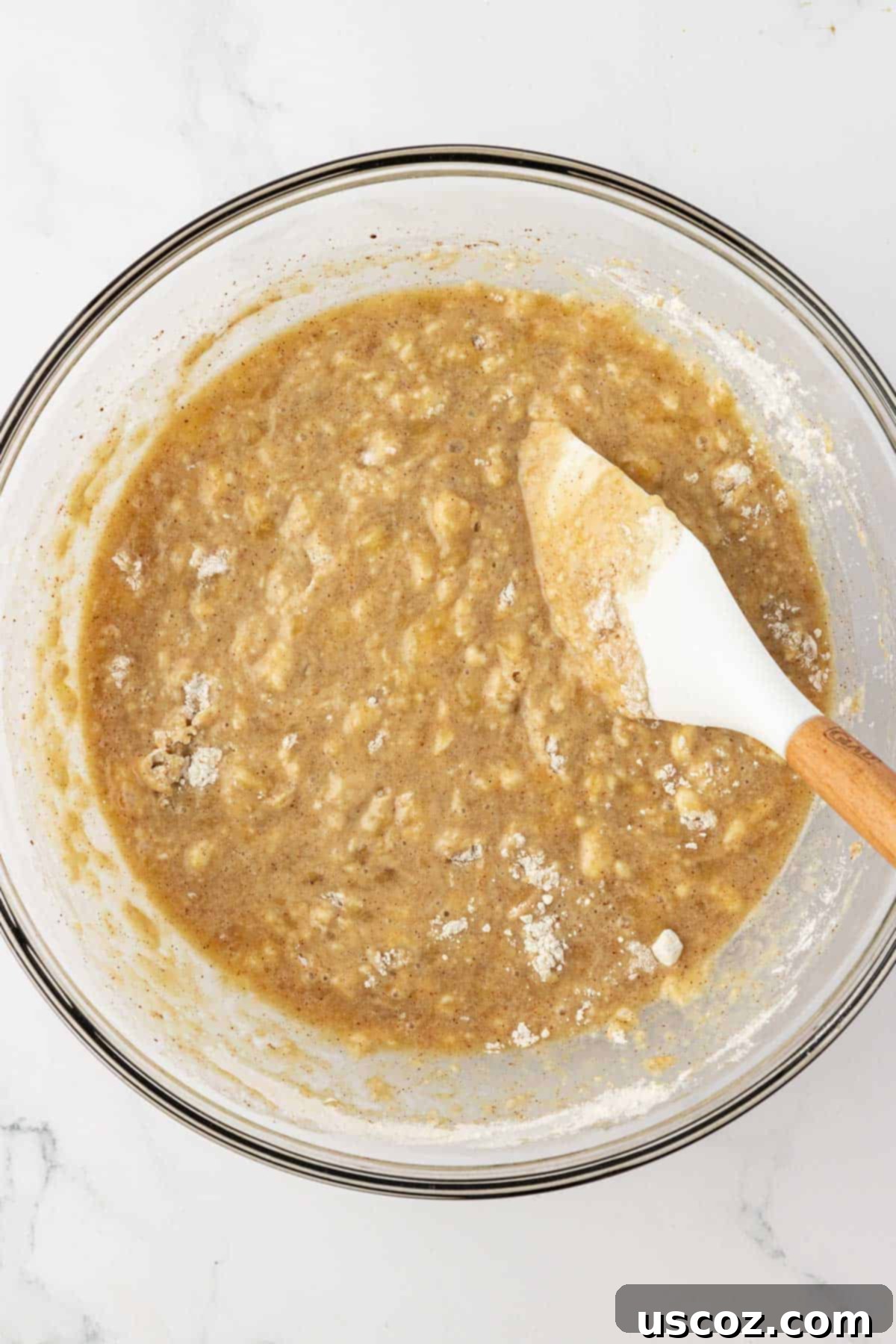 Deliciously Healthy Banana Muffins 10 banana muffin batter mixed together in a bowl