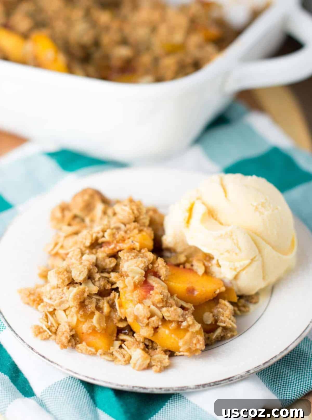 Delicious & Easy Peach Crisp 8 A serving of warm peach crisp with a golden, crunchy topping on a plate